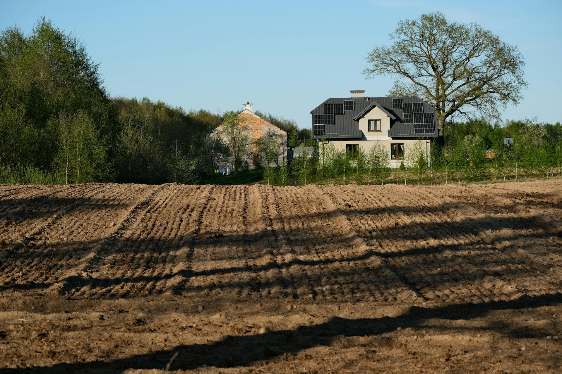 Modernūs saulės moduliai sumontuoti ant naujos statybos gyvenamojo namo stogo.